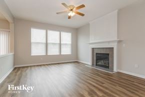 Kansas City house for rent - a living room with a fireplace and a ceiling fan