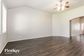 Missouri City house for rent - A spacious room with wooden floors and a ceiling fan.