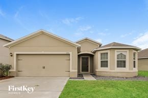 Port Orange house for rent - a beige house with a driveway and a lawn