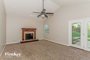 Mason house for rent - a living room with a fireplace and a ceiling fan