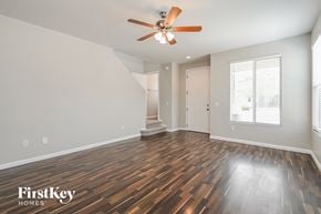 Tucson house for rent - A room with a wooden floor and a ceiling fan.