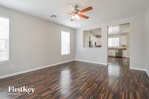 Tucson house for rent - A spacious room with wooden flooring and a ceiling fan.