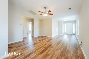 Summerville house for rent - an empty living room with a ceiling fan and wood floors