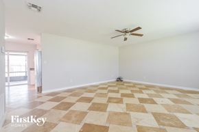 Ocoee house for rent - an empty living room with a ceiling fan and a checkered floor