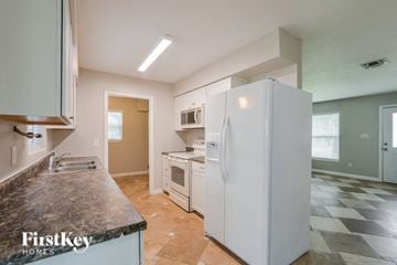 Ocoee house for rent - a kitchen with a white refrigerator and a sink