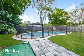 Ocoee house for rent - a swimming pool with a fence around it in a backyard