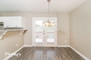 Greensboro house for rent - A well-lit room with a wooden floor and a white door.