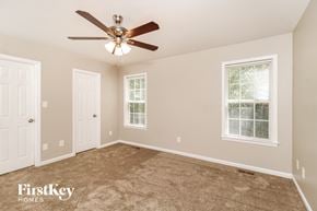 Greensboro house for rent - A spacious room with a ceiling fan and two windows.