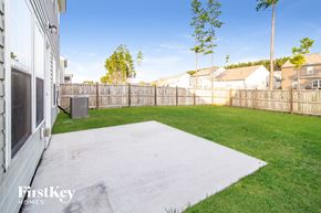 Summerville house for rent - a backyard with a fence and green grass and a yard and a house