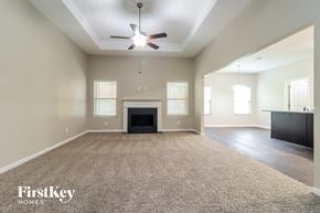 Dallas house for rent - A spacious living room with a fireplace and a ceiling fan.