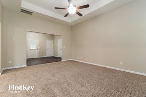 Dallas house for rent - A spacious room with a carpeted floor and a ceiling fan.