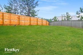 Dallas house for rent - A grassy field with a wooden fence and trees in the background.