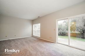 Galloway house for rent - A room with a carpeted floor and a sliding glass door leading to a backyard.