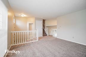 Galloway house for rent - A spacious room with a staircase and a window with blinds.