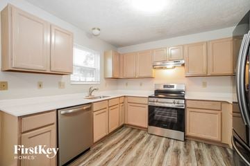 Galloway house for rent - A kitchen with wooden cabinets and a stainless steel oven.