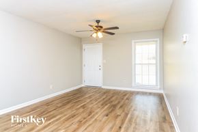 Powder Springs house for rent - A room with a wooden floor and a ceiling fan.