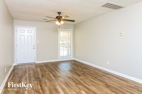 Powder Springs house for rent - A room with wooden floors and a ceiling fan.