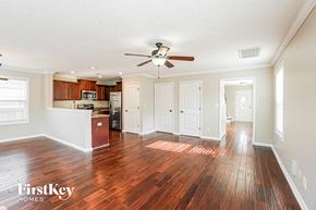 Clarksville house for rent - A spacious room with wooden floors and a ceiling fan.