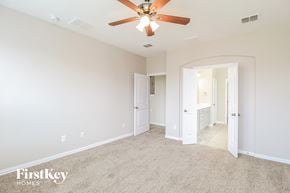 Haslet house for rent - a master bedroom with carpet and a ceiling fan