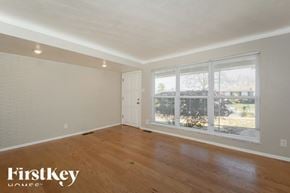 Saint Louis house for rent - A room with wooden floors and a large window with blinds.