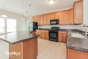 Mooresville house for rent - a kitchen with wooden cabinets and black appliances