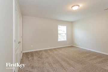 Mooresville house for rent - a spacious living room with carpet and a window