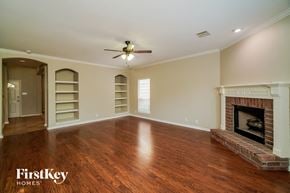 San Antonio house for rent - a living room with a fireplace and a ceiling fan