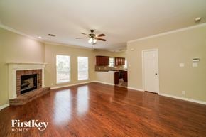 San Antonio house for rent - an empty living room with a fireplace and a ceiling fan