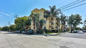 North Hollywood apartment for rent - a yellow apartment building on a street corner with palm trees