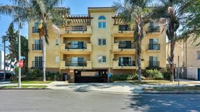 North Hollywood apartment for rent - a yellow apartment building with palm trees in front of it