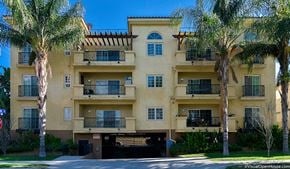 North Hollywood apartment for rent - a yellow apartment building with palm trees in front of it