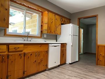 Canton apartment for rent - A kitchen with wooden cabinets and a white dishwasher.