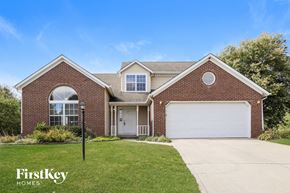Indianapolis house for rent - A brick house with a garage door and a window.