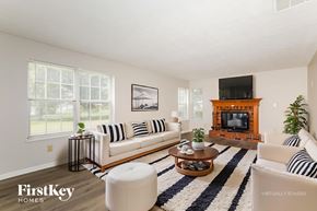 Indianapolis house for rent - A living room with a white couch, a coffee table, and a fireplace.