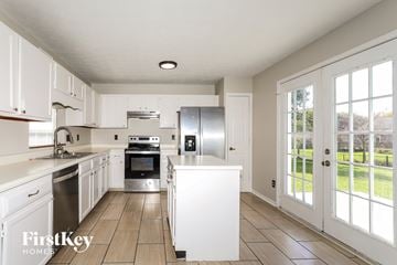 Indianapolis house for rent - A kitchen with white cabinets and a refrigerator.
