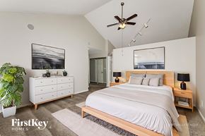 Indianapolis house for rent - A bedroom with a large bed, a dresser, and a ceiling fan.