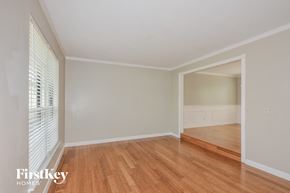 O'fallon house for rent - the living room and dining room with wood flooring and a large window