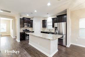 Summerville house for rent - a kitchen with black cabinets and a granite counter top