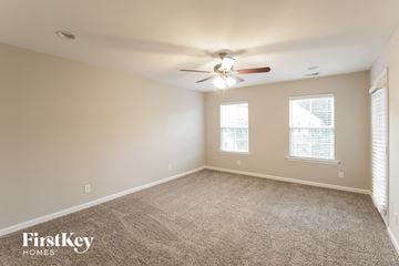 Summerville house for rent - a spacious living room with carpet and a ceiling fan