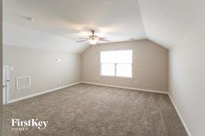 Summerville house for rent - a bedroom with carpet and a ceiling fan and a window