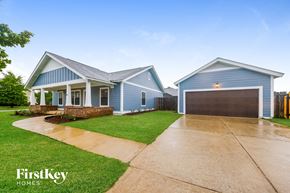 Calera house for rent - A blue house with a garage is shown in the image.