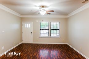 Calera house for rent - A room with a wooden floor and a ceiling fan.