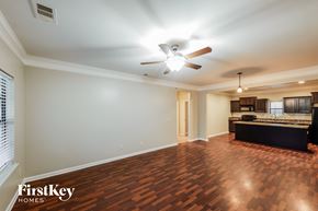 Calera house for rent - A spacious room with a ceiling fan and wooden flooring.