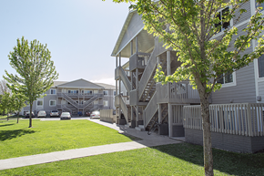 Ames apartment for rent - a view of the exterior of a building with stairs and a green lawn