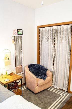 Ames apartment for rent - a room with a chair and a curtain and a bed
