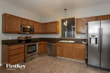 Noblesville house for rent - a kitchen with wooden cabinets and stainless steel appliances