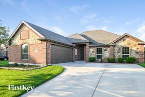 Red Oak house for rent - A brick house with a garage door and a driveway.