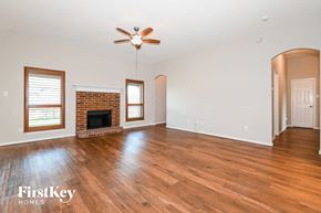 Red Oak house for rent - A spacious room with a fireplace and wood flooring.