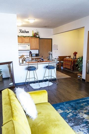 Ames apartment for rent - a living room with a kitchen and a yellow couch