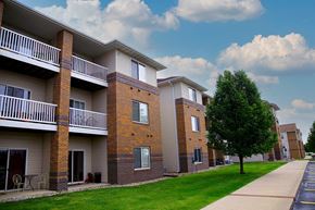Ames apartment for rent - a row of brick and white apartment buildings on a sidewalk